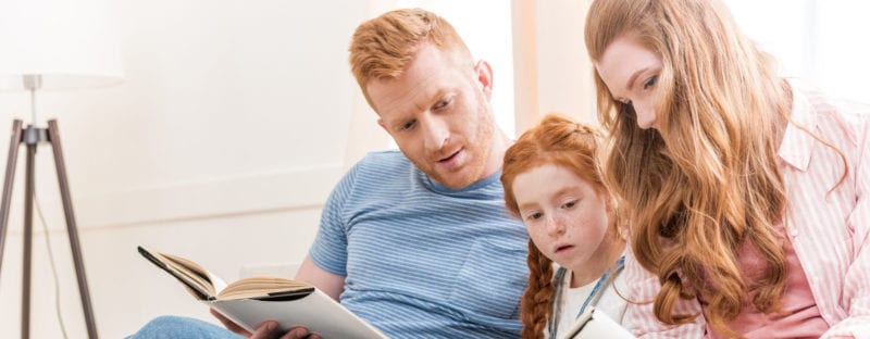 mom and dad reading with little red haired girl; coparenting