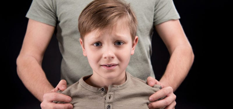 man holding young boy by shoulders; parental kidnapping