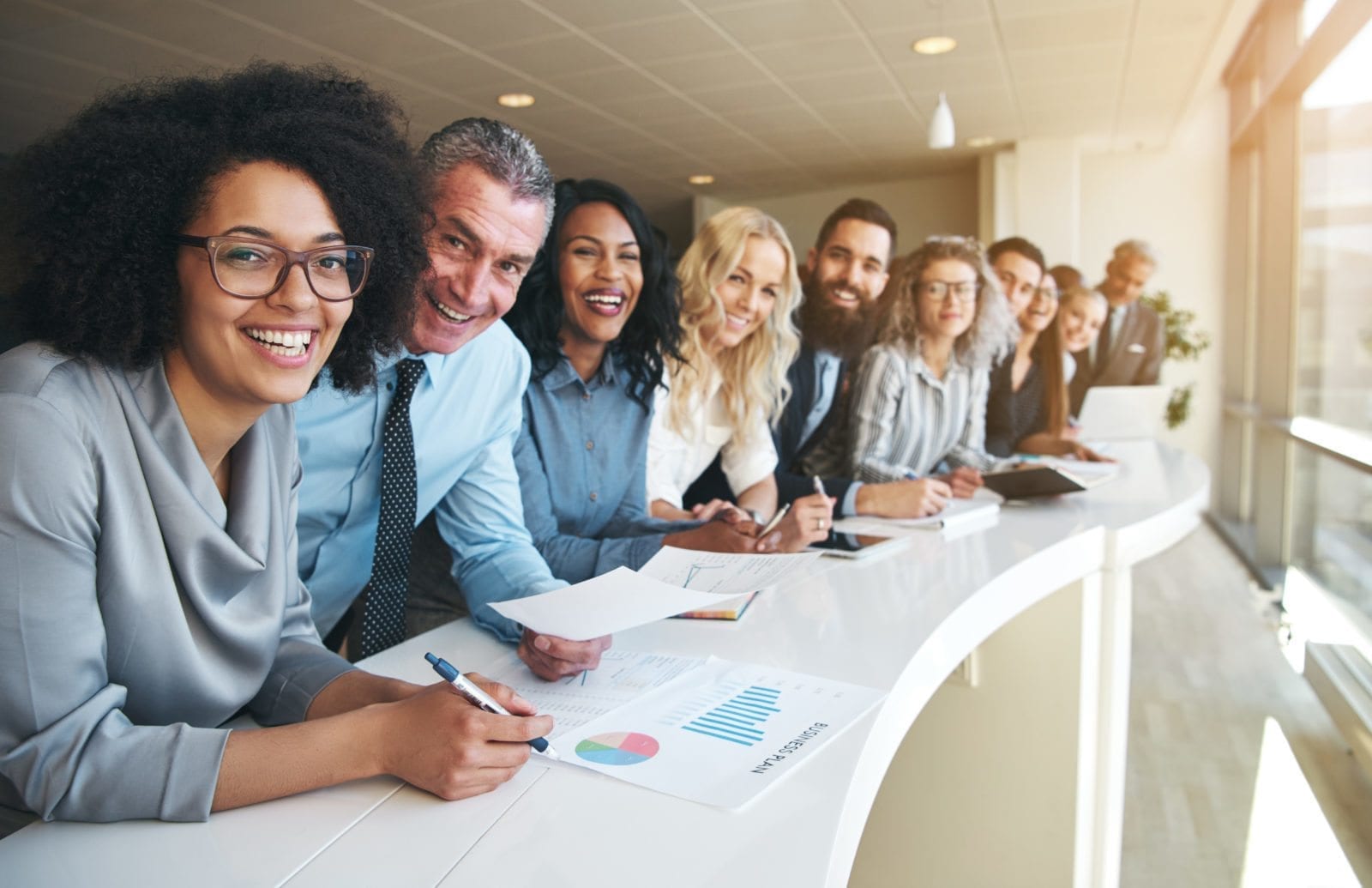 Cheerful multiracial colleagues looking at camera in office Smiling black and white coworkers looking at camera in the office.